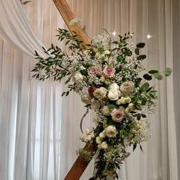 Large floral arrangement with white and blush roses on a wooden frame