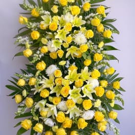 Standing floral spray with yellow roses, white lilies, and white mums