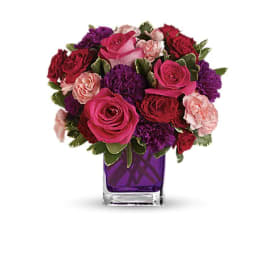 Pink and red roses with purple carnations in a purple vase