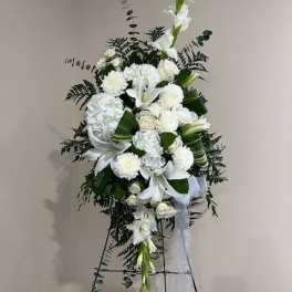 Tall white floral standing spray with lilies and mums on an easel