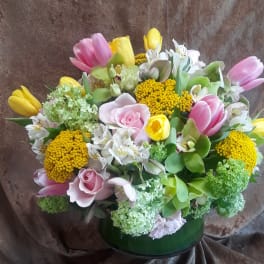 Mixed bouquet of pink and yellow tulips with roses in a green vase