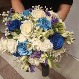 Large bouquet of blue, white, and purple roses with small white filler flowers
