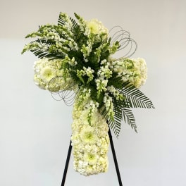Tall white floral standing spray on a black easel