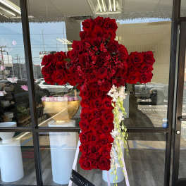 Large cross-shaped arrangement of red roses with white orchid accents