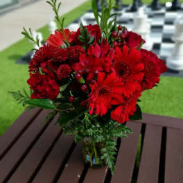 Red mixed flower bouquet in a glass vase