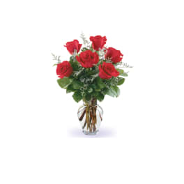 Red roses arranged in a clear glass vase