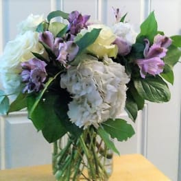 Bouquet of white and purple flowers in a clear glass vase