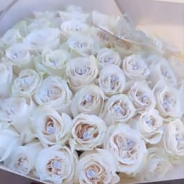 Bouquet of white roses in a pale box with a "50 roses" label