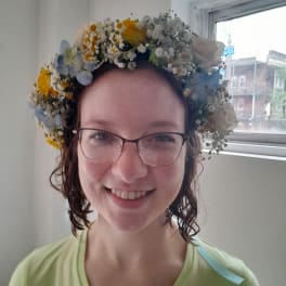 Woman wearing a floral crown of white, yellow, and blue flowers