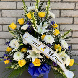 Yellow roses and white lilies with a memorial ribbon