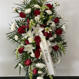 Standing funeral spray of red roses and white lilies with a memorial ribbon