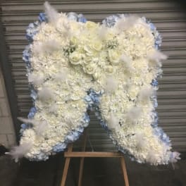 Large white floral standing spray on an easel with pale blue accents