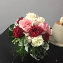 Bouquet of pink, red, and white roses in a low glass vase