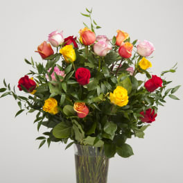 Tall bouquet of multicolored roses in a clear glass vase