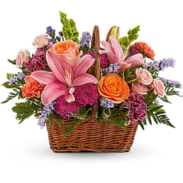 Basket arrangement with pink lilies, roses, and mixed blooms