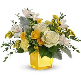 Yellow and white rose bouquet in a square glass vase