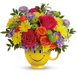 Colorful bouquet in a yellow smiley-face mug