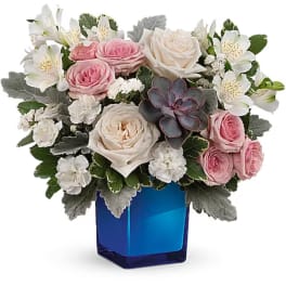 Pink and white roses arranged in a blue glass vase