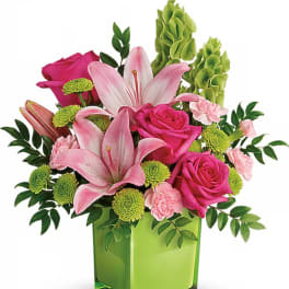 Pink lilies and roses in a green vase with green button mums