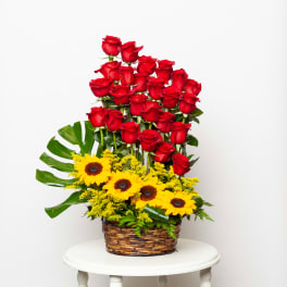 Basket arrangement of red roses and yellow sunflowers