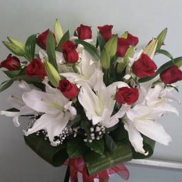Bouquet of red roses and white lilies with a red ribbon