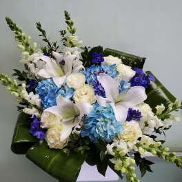 Blue and white floral arrangement with lilies and roses