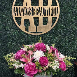 Pink and white floral arrangement in a silver container