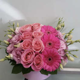 Pink roses and gerbera daisies in a round box arrangement