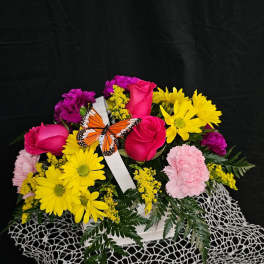 Pink roses and yellow daisies in a white basket with a butterfly decoration
