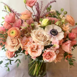 Pink and peach bouquet with roses and anemones in a glass vase
