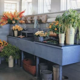 Assorted floral arrangements in buckets on a worktable