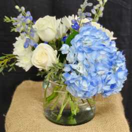 Blue hydrangeas and white roses in a glass vase