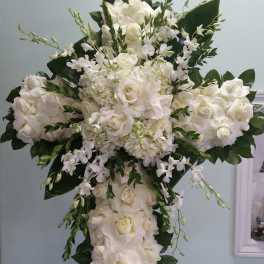 Large white floral cross arrangement with roses and orchids