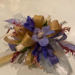 Small corsage with purple flowers and gold ribbon