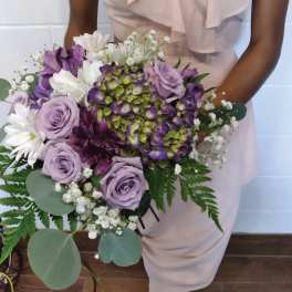 Woman holding a bouquet of lavender roses, white daisies, and purple hydrangea