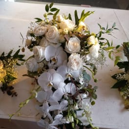 White rose and orchid bouquet with trailing greenery