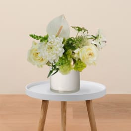 White roses and anthurium arranged in a glass vase