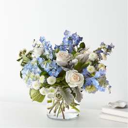 Blue and white flower arrangement in a clear glass vase