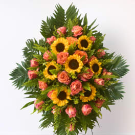 Standing floral spray with sunflowers and pink roses on a metal easel