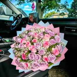 Bouquet of pink and lavender roses with baby's breath in pastel wrap
