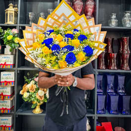 Bouquet of blue and yellow roses wrapped in layered paper
