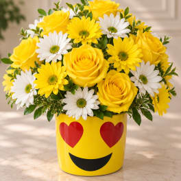 Yellow roses and white daisies in a yellow emoji vase