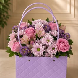 Pink and purple flower arrangement in a lavender basket