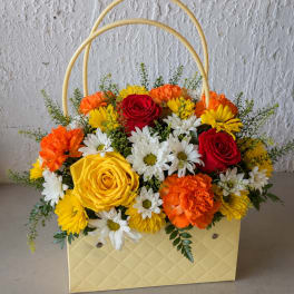 Basket arrangement of red and yellow roses with white daisies and orange carnations