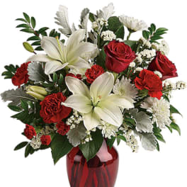 Red roses and white lilies in a red glass vase