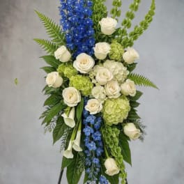 Standing floral spray with white roses, blue delphinium, and green hydrangea