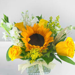 Sunflower and yellow rose bouquet in a glass vase