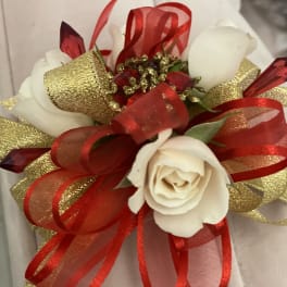 White rose corsage with red and gold ribbon accents