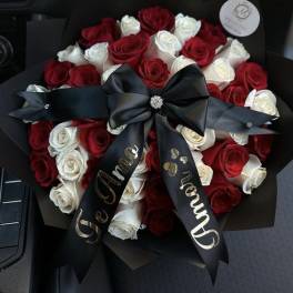 Bouquet of red and white roses wrapped with a black ribbon