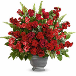 Red rose and carnation arrangement in a gray urn vase